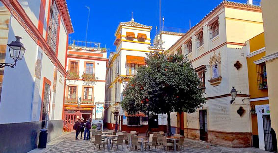 Voyage à moto en Andalousie : place d'un village typique avec ses maisons colorées dans le le quartier Andalou au coeur de Séville