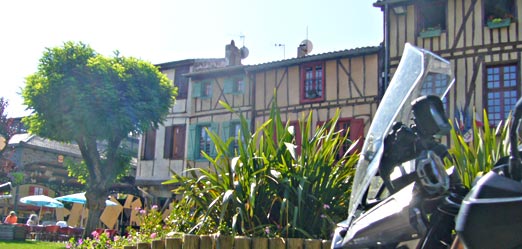 pause café lors de cette location moto à la journée dans le Tarn : photo d'une moto garée sur une jolie place du Tarn