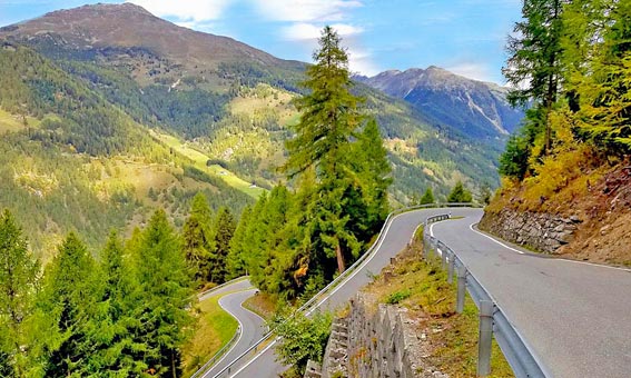Route en lacets dans une vallée des Dolomites (col vers Maloja)